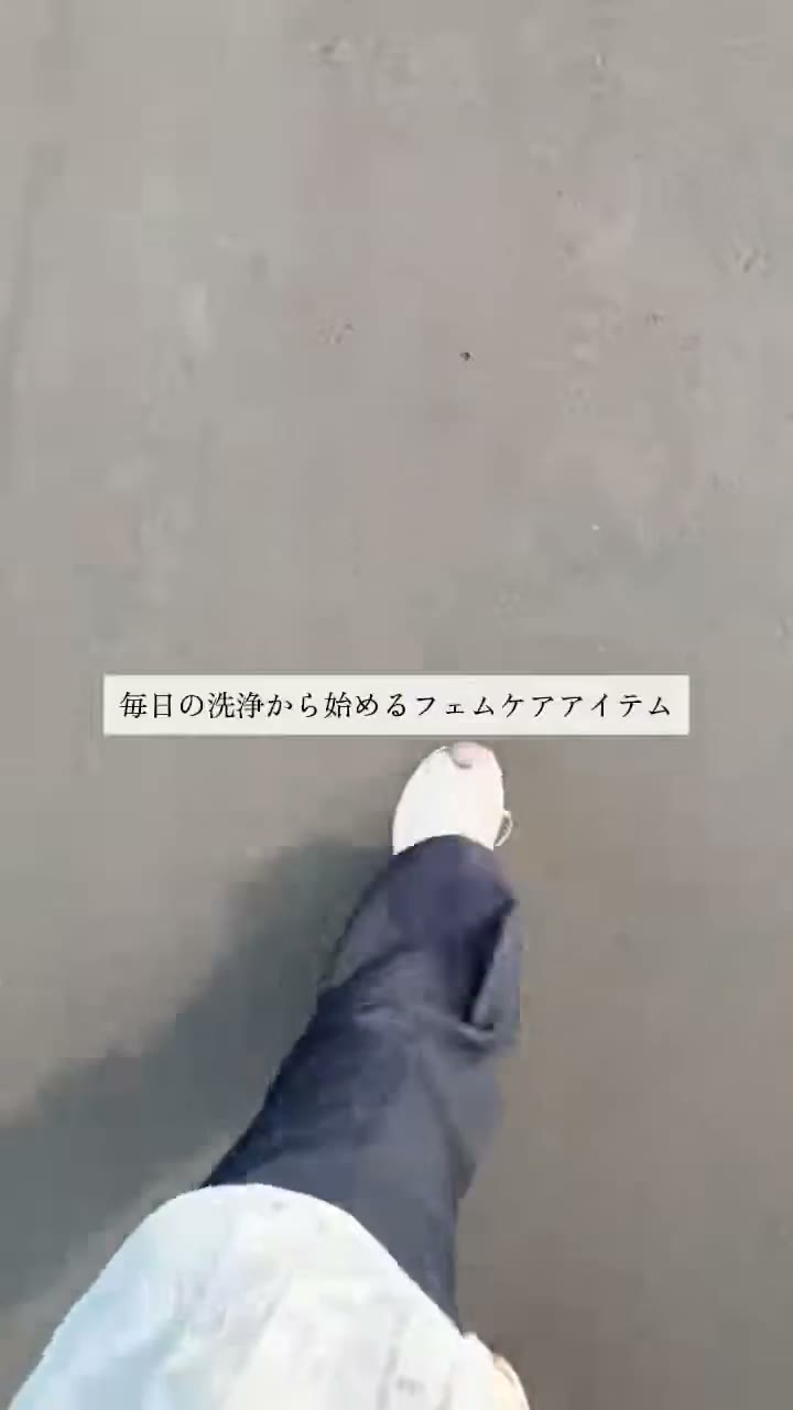 グレーの床の上を、白いスニーカーで歩き出す足元の場面