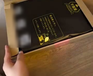 段ボール箱の中に、芋國屋のロゴが入った黒い袋が入っている様子