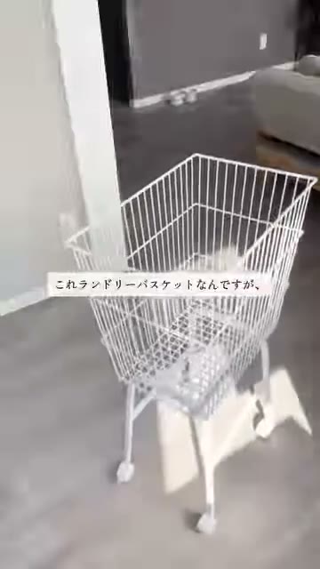 白いワイヤーの角型かごを、キャスター付きの脚にのせたワゴンが床に置かれている様子