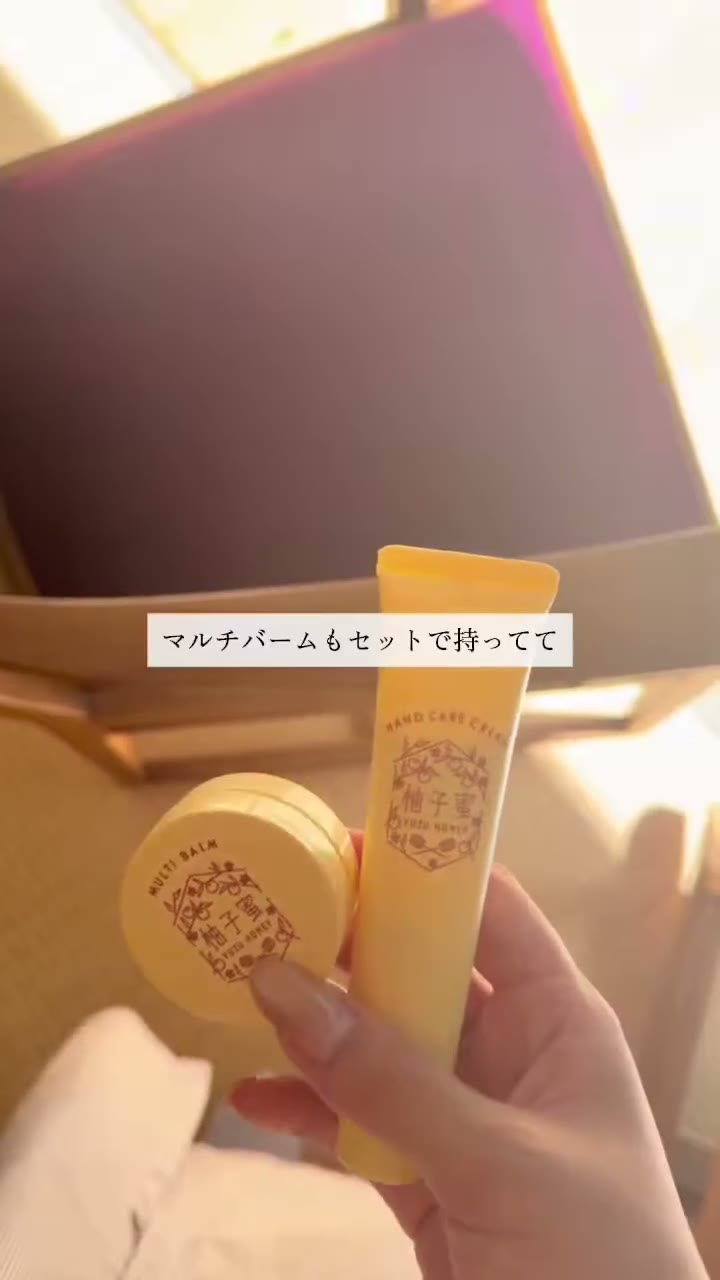 柚子蜜のロゴが入った黄色のチューブと、丸い容器を片手で持っている場面